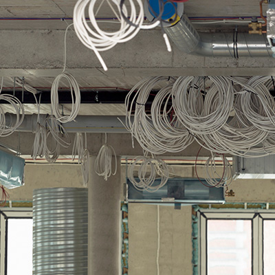 Structured cabling installation with coiled wires in a commercial space.