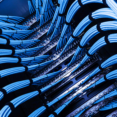 Structured cabling with blue fiber and copper cables organized in a network cabinet.