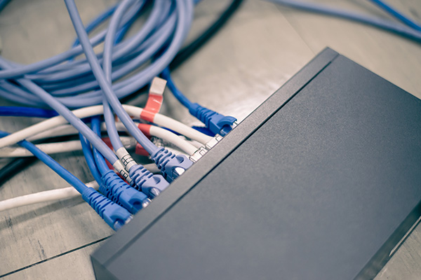 Structured cabling installation with multiple Ethernet cables connected to a network switch.
