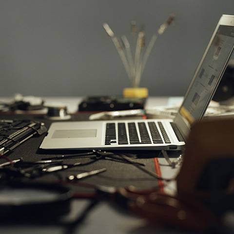 Laptop on a workbench surrounded by tools and equipment for network installation.