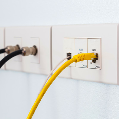 Yellow Ethernet cable connected to LAN port in structured cabling installation.
