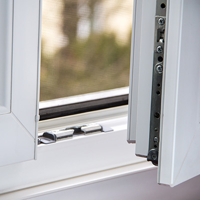 Close-up of a white window frame slightly open with hinge mechanism visible.