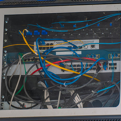 Network switch and tangled cables in a structured cabling installation showcase.