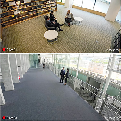 Office environment with people discussing, bookshelves in background and modern architecture.