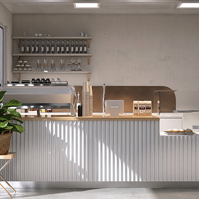Modern café counter with coffee equipment and plants in a bright setting.